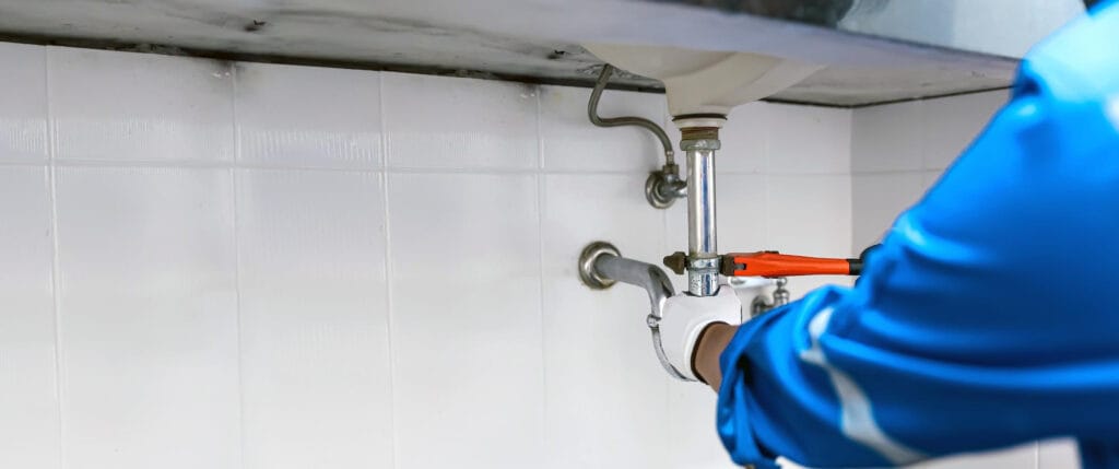 Expert technician fixing leaky pipes